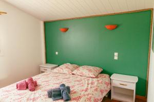 1 dormitorio con 1 cama con pared verde en Les Jardins de La Palaire - Gîte T2 avec jardin, en Cugand