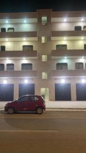a car is parked in front of a building at Faraseen Apartments in Al Qasţal