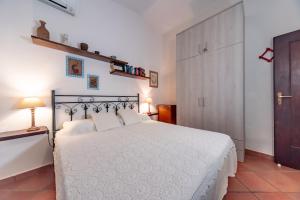 a bedroom with a bed with a white bedspread at Villa Monica in Costa Rei
