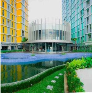 a building with a pond in the middle of a city at Apt Pejaten Park 1 BR Sage Smart TV, Netflix, Prime, Youtube in Jakarta