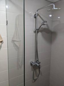 a shower with a glass door in a bathroom at Apt Pejaten Park 1 BR Sage Smart TV, Netflix, Prime, Youtube in Jakarta