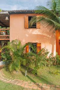 uma casa com uma palmeira em frente em Pousada Habitat Caraiva em Caraíva