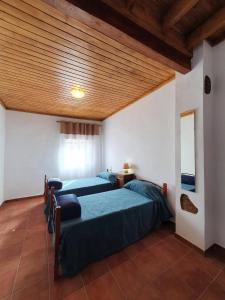 een slaapkamer met 2 bedden en een houten plafond bij CASA BAUTISTA - ROTGLÀ in Rotglá y Corbera