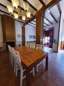 une salle à manger avec une table en bois et des chaises blanches dans l'établissement CASA BAUTISTA - ROTGLÀ, à Rotglá y Corbera