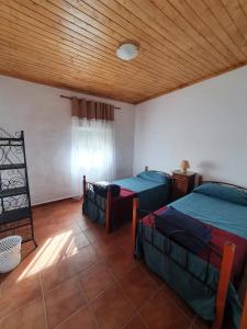 une chambre avec deux lits et un plafond en bois dans l'établissement CASA BAUTISTA - ROTGLÀ, à Rotglá y Corbera