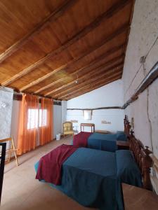 een slaapkamer met 2 bedden en een houten plafond bij CASA BAUTISTA - ROTGLÀ in Rotglá y Corbera