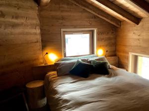 a bedroom with a bed in a log cabin at Chalet de la Marmotte à Valloire in Valloire