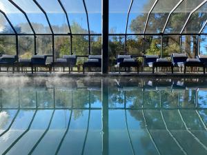 a swimming pool with chairs and water in a building at Ort Hotel in Campos do Jordão