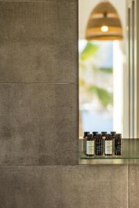 a row of bottles of essential oils on a glass shelf at Akrotiri Hotel in Parikia