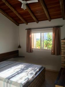 Schlafzimmer mit einem Bett und einem Fenster in der Unterkunft Pousada dos Sambaquis in Jaguaruna