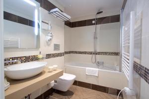 a bathroom with a sink and a tub and a toilet at Grand Hotel Park in Dubrovnik