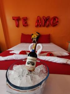 Una botella de champán en un cubo en una cama en La Casa De Mi Sub, en Puerto Baquerizo Moreno