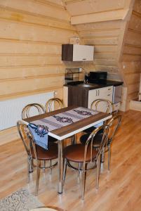 Agroturystyka na starej drodze في فيتوف: مطبخ مع طاولة وكراسي في غرفة