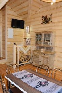 a dining room with a table and chairs in a cabin at Agroturystyka na starej drodze in Witów