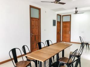 a conference room with a wooden table and chairs at Akiri Surf Residence in Thulusdhoo
