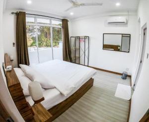 um quarto com uma cama grande e uma janela em Akiri Surf Residence em Thulusdhoo