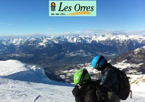 un homme assis au sommet d'une montagne enneigée dans l'établissement Maison CAILLE, à Embrun