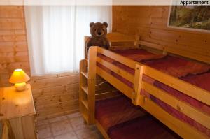 - un ours en peluche assis sur un lit superposé dans un dortoir dans l'établissement La petite source, à Florenville