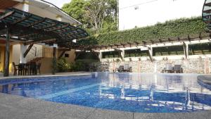 a swimming pool with a pergola next to a house at Zafra Hotel in Ceiba Blanca
