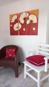 una habitación con una silla y una pintura floral en la pared en A metros de la Playa...., en Federación