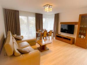 a living room with a couch and a table at Aparts Care Balic Polanki in Kołobrzeg