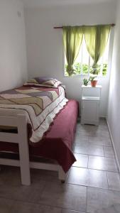 ein kleines Schlafzimmer mit einem Bett und einem Fenster in der Unterkunft A metros de la Playa.... in Federación