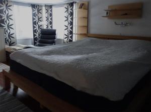 um quarto com uma cama grande e uma cadeira em 1B, Stuga m havsutsikt & 50m till strand em Byxelkrok