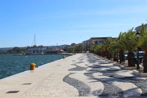 a long pier with palm trees and water at Rouchotas Apartments in Argostoli