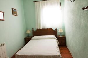 a small bedroom with a bed and a window at Apartamentos Rurales Mayorazgo in Cañete