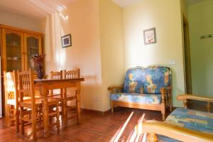 a living room with a table and chairs and a chair at Apartamentos Rurales Mayorazgo in Cañete