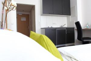 
a room with a bed, chair, desk and television at Hotel Rappensberger in Ingolstadt
