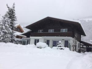 ein schneebedecktes Haus vor der Tür in der Unterkunft Apartment Wildalmblick in Neukirchen am Großvenediger