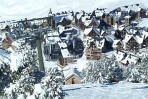 una ciudad cubierta de nieve con un remonte en Hotel Chalet Bassibe by Silken, en Baqueira Beret