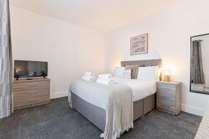 een slaapkamer met een bed en een televisie bij Caemawr Place - Stylish Home TV in Every Bedroom! in Swansea