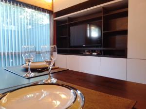 dos copas de vino sentadas en una mesa con TV en EDIFICIO VIVERo 3, en San Martín de los Andes
