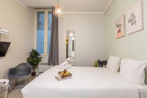 a bedroom with a large white bed and a chair at Apartments WS Louvre - Saint Honoré in Paris