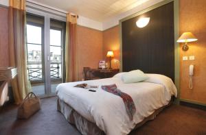 a hotel room with a large bed and a window at Hotel De Gramont in Pau