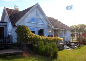 ein kleines Haus mit einer Veranda und einem Hof in der Unterkunft 1B, Stuga m havsutsikt & 50m till strand in Byxelkrok