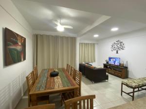 a dining room with a table and chairs and a television at Juquehy Casa para Famílias em condomínio in Juquei