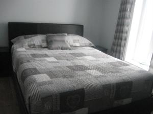 a bed with a quilt on it in a bedroom at Gite la Maison Rochefort in Baie-Sainte-Catherine