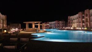 a large swimming pool at night with lights at Oyster Bay Marsa Alam ( Unit I5-06) in Abu Dabbab