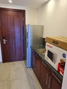 a kitchen with a refrigerator and a sink and a door at Oyster Bay Marsa Alam ( Unit I5-06) in Abu Dabab