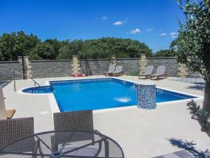 einen Pool mit Stühlen und eine Terrasse mit Pool in der Unterkunft Apartments Svarog in Biograd na Moru