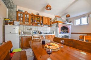 eine Küche mit einem Holztisch und einem Kamin in der Unterkunft Apartments Svarog in Biograd na Moru