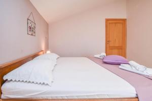 ein Schlafzimmer mit einem weißen Bett mit zwei Handtüchern darauf in der Unterkunft Apartments Svarog in Biograd na Moru