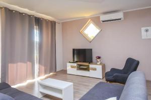 ein Wohnzimmer mit Couch und Fernseher in der Unterkunft Apartments Svarog in Biograd na Moru