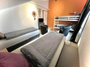 a room with two beds and a bunk bed at VIVA Hostel in Chur