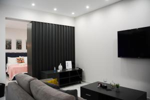 a living room with a couch and a flat screen tv at DAFNI LUXURY SUITES in Athens