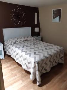 a bedroom with a bed with a black and white comforter at Gite la Maison Rochefort in Baie-Sainte-Catherine