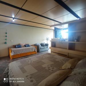 1 dormitorio con 2 camas y sofá en Apart club San Pedro en San Pedro